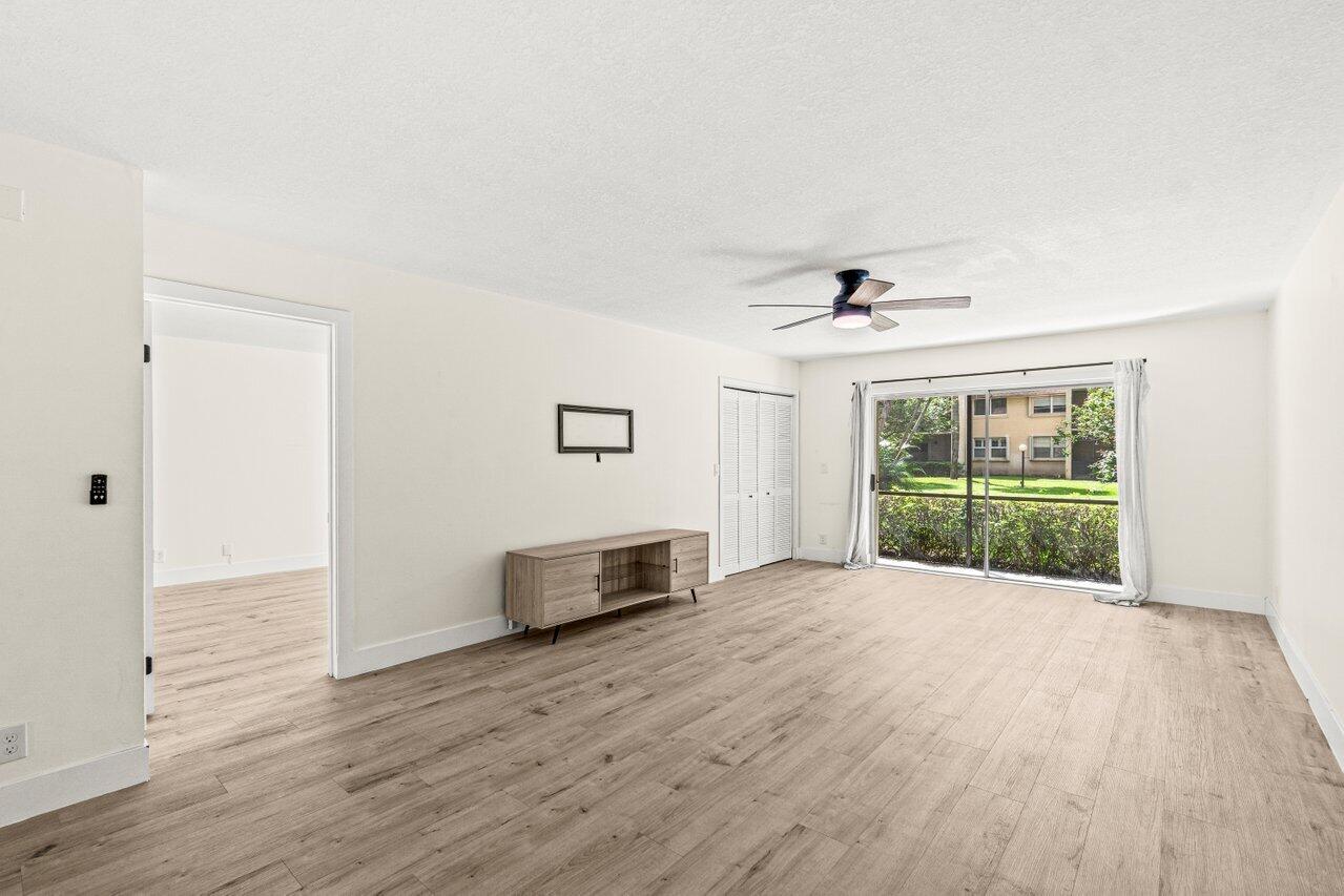 2935 Southwest 22nd Avenue, Unit 1060 Delray Beach, FL 33445 - Photo 9 of 21 a view of an empty room with wooden floor and a window