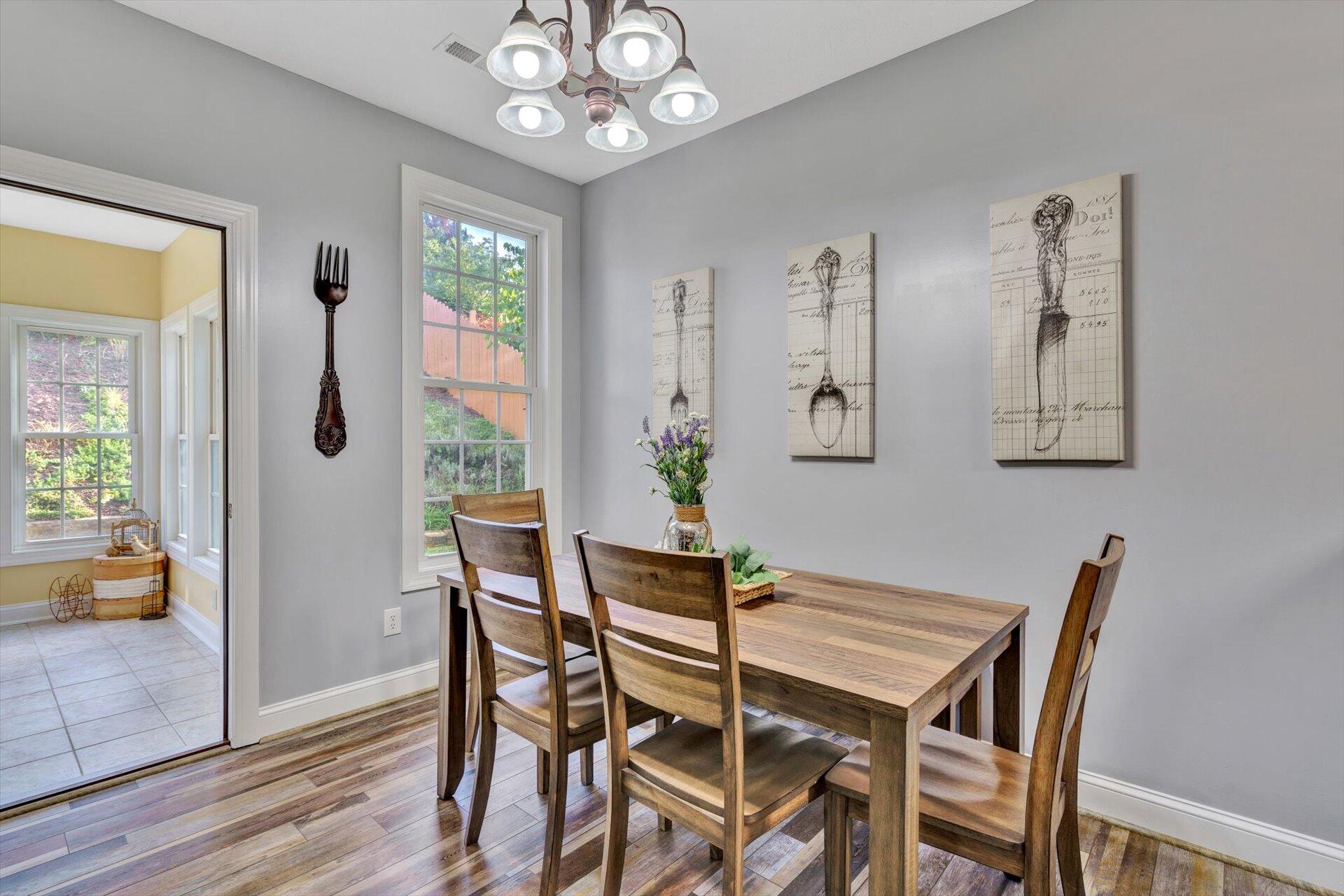 1217 Mountain View Road Vinton, VA 24179 - Photo 13 of 31 a dining room with wooden floor a chandelier a wooden table and chairs
