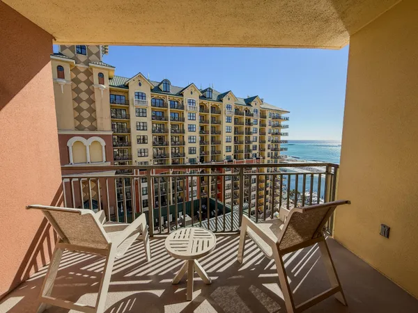 a view of balcony with chairs and wooden fence