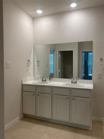 a bathroom with a double vanity sink and mirror
