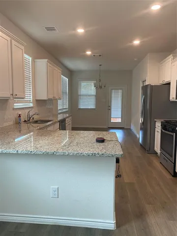 a kitchen with granite countertop cabinets stainless steel appliances a sink and a counter top space