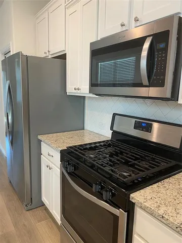 a stove top oven sitting inside of a kitchen