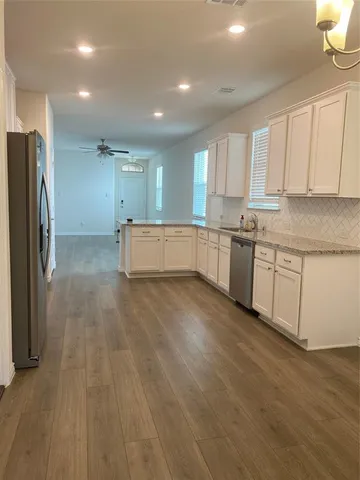 a large kitchen with a lot of counter space and stainless steel appliances