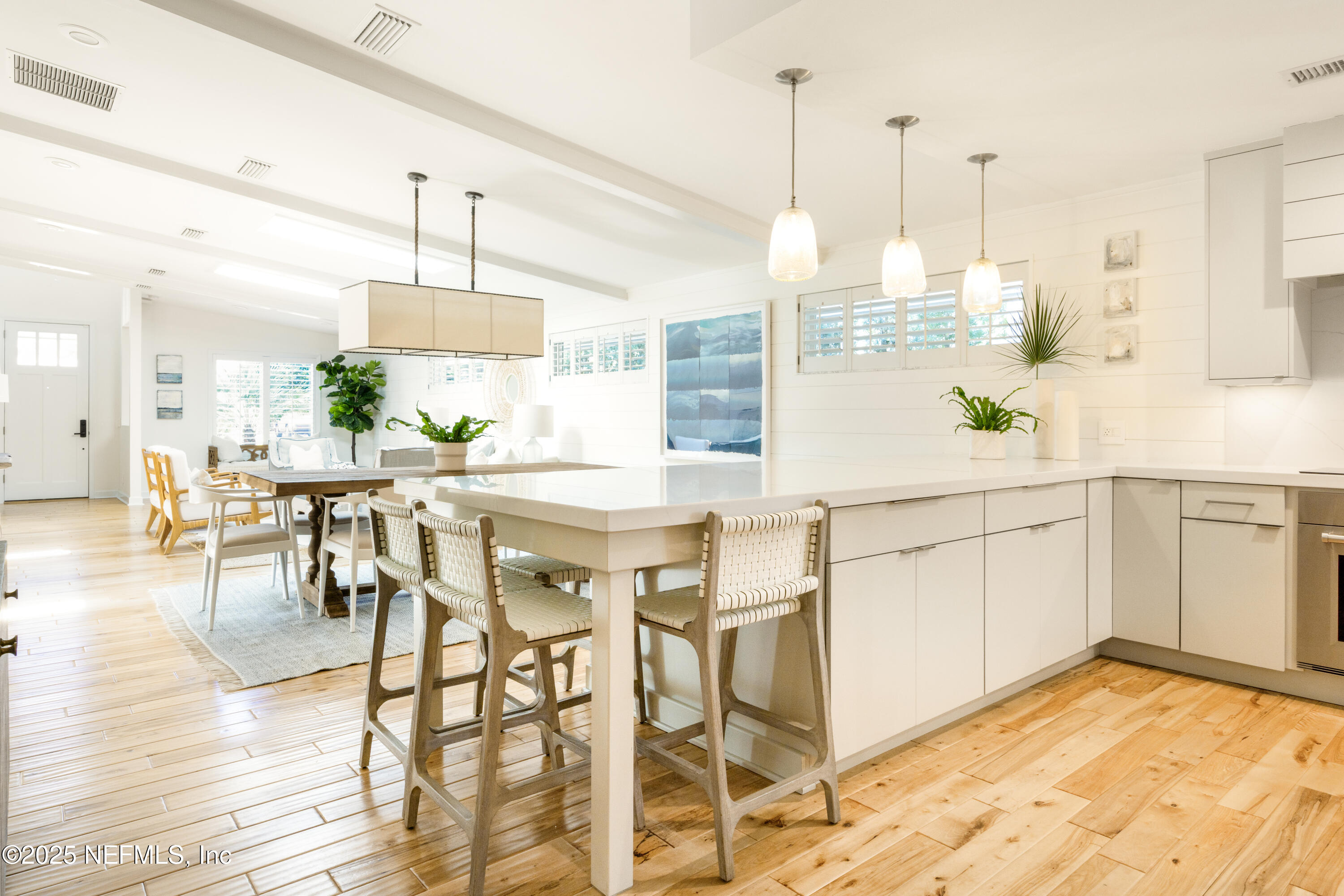 440 Ocean Boulevard Atlantic Beach, FL 32233 - Photo 7 of 34 a kitchen with stainless steel appliances kitchen island granite countertop a table chairs and white cabinets