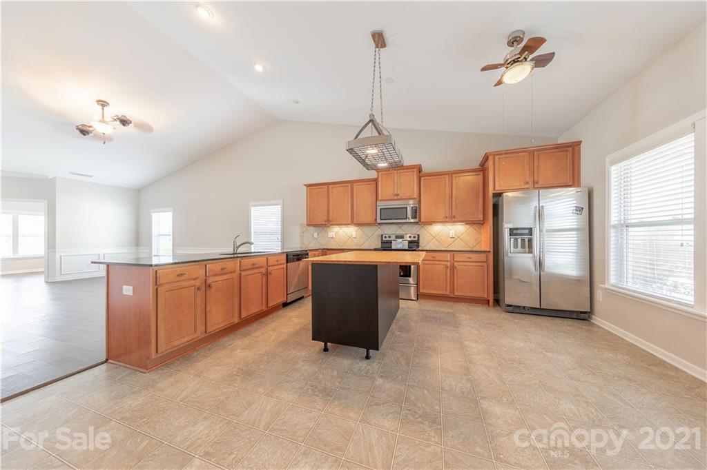 8026 Bryson Road Indian Land, SC 29707 - Photo 19 of 33 a kitchen with stainless steel appliances granite countertop a refrigerator a sink dishwasher a oven with white cabinets and countertops