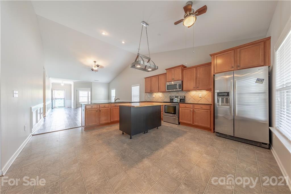 8026 Bryson Road Indian Land, SC 29707 - Photo 20 of 33 a kitchen with stainless steel appliances kitchen island a refrigerator sink and cabinets