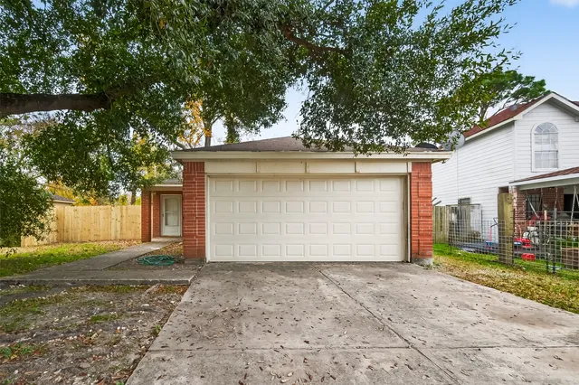 a view of a house with a yard and large tree
