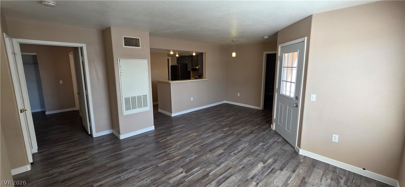 1830 North Pecos Road, Unit 142 Las Vegas, NV 89115 - Photo 8 of 19 Hardwood-style flooring extends across the open-concept living area, connecting to a modern kitchen with a breakfast bar.