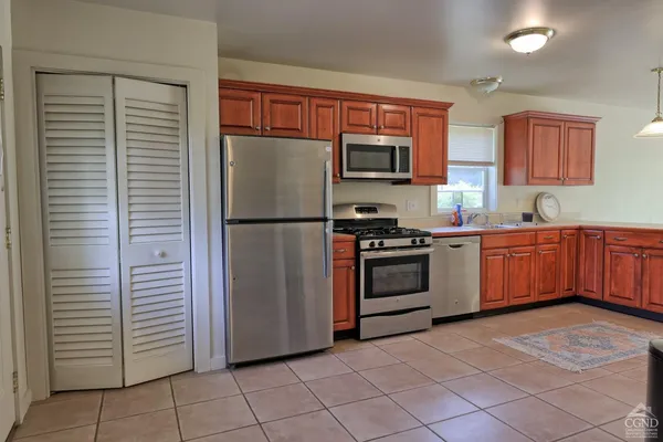 a room with kitchen island granite countertop a sink a counter top space and cabinets