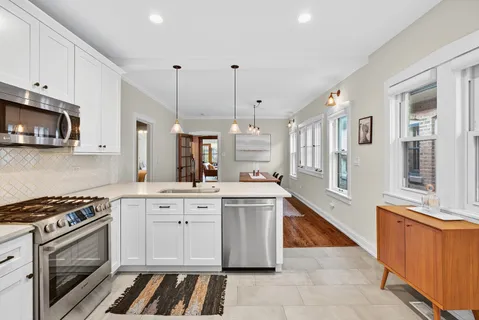a kitchen with stainless steel appliances a stove a sink and a microwave