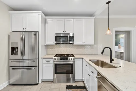 a kitchen with white cabinets and stainless steel appliances