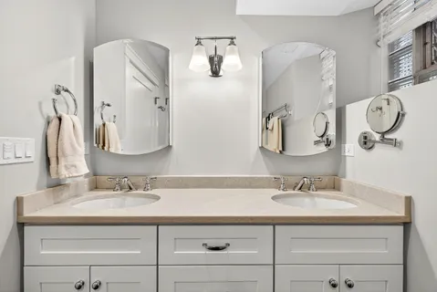a bathroom with a double vanity sink and a mirror