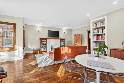 a living room with furniture a dining table and a bookshelf