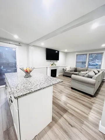 a living room with granite countertop furniture and a flat screen tv