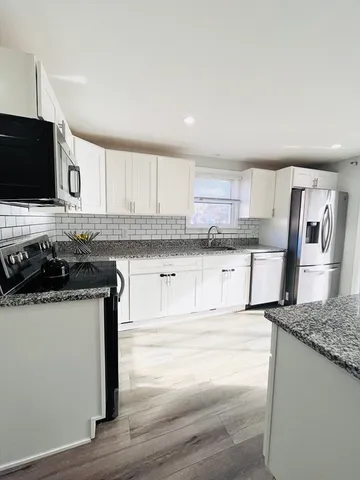 a kitchen with stainless steel appliances granite countertop a sink stove and microwave