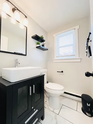 a bathroom with a sink mirror vanity and toilet