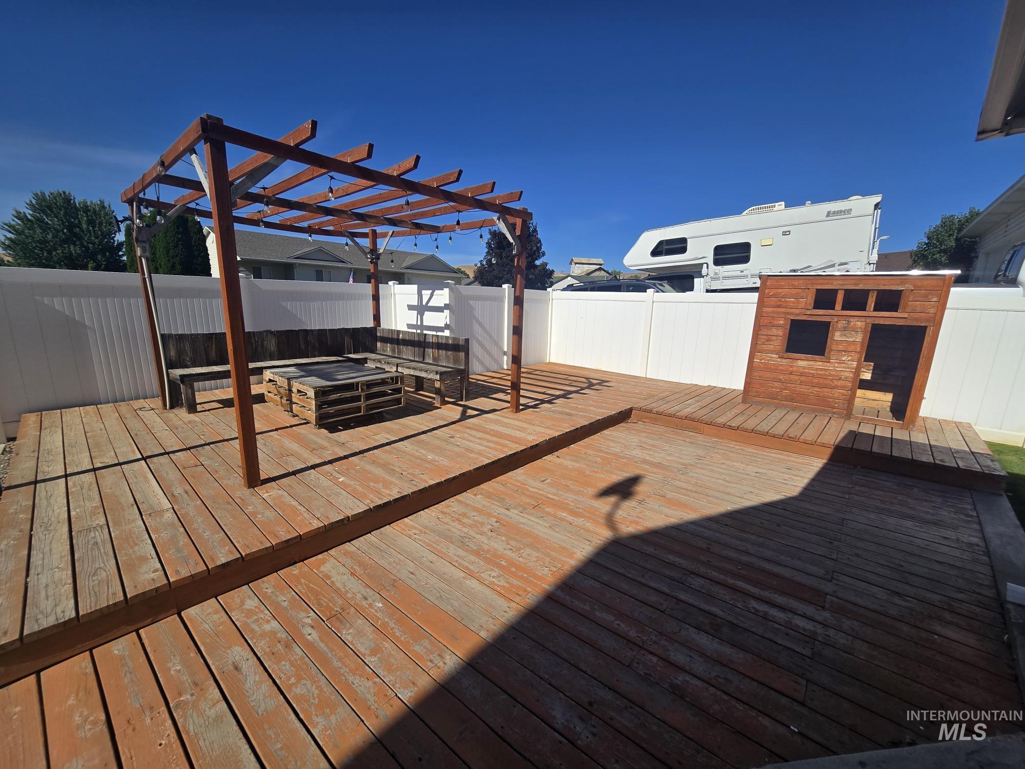 2480 West 9th Street Weiser, ID 83672 - Photo 9 of 17 Multi-level wood decking featuring a pergola with string lighting and built-in benches