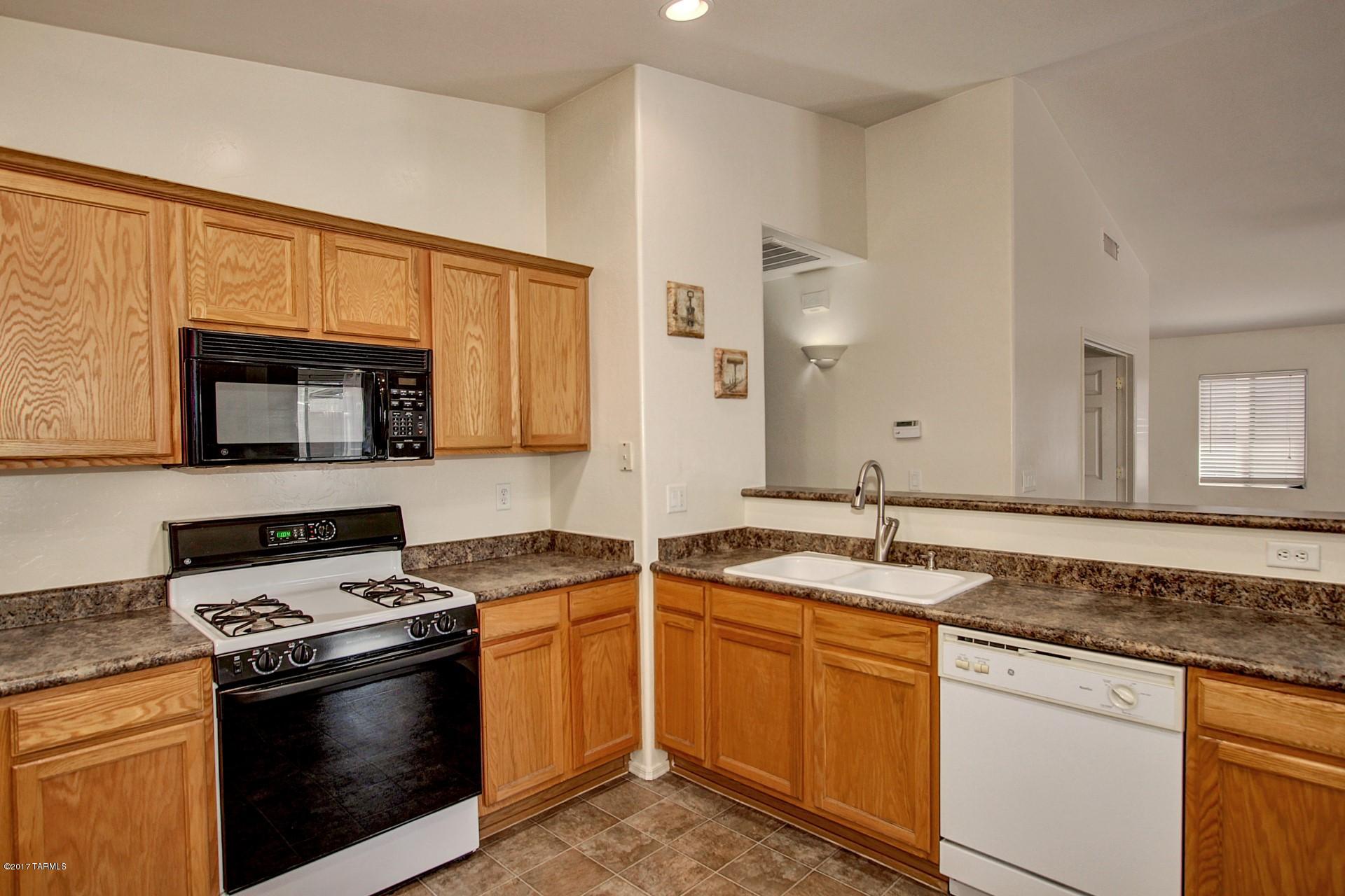 8350 East Bowline Road Tucson, AZ 85710 - Photo 6 of 26 a kitchen with stainless steel appliances granite countertop a sink stove and microwave