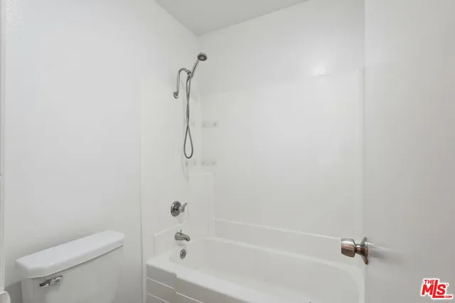a bath room with a toilet and a bath tub
