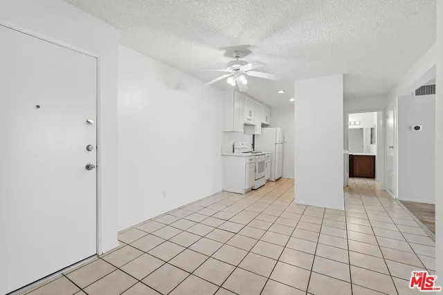 a view of an empty room and kitchen view