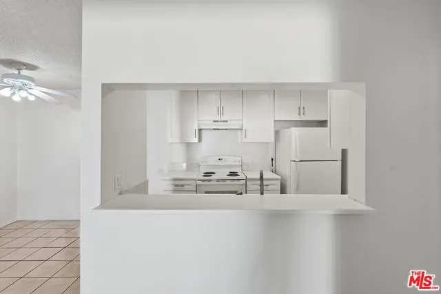 a kitchen with kitchen island white cabinets and stainless steel appliances