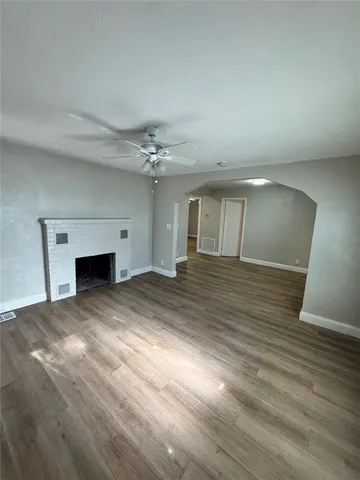 a view of empty room with wooden floor and fireplace