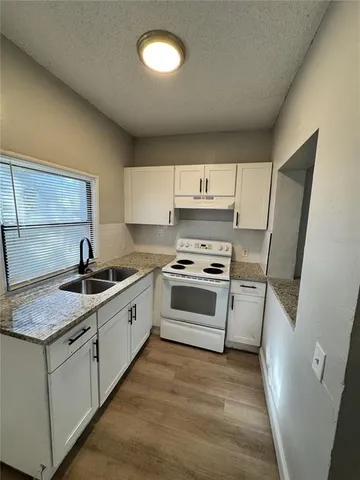 a kitchen with white cabinets sink and appliances