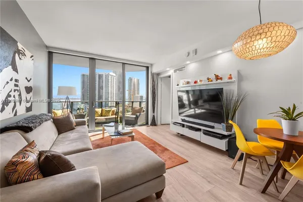 a living room with furniture a rug and a floor to ceiling window