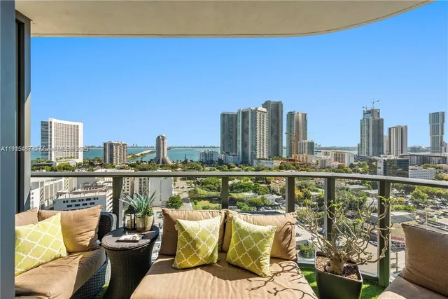 a view of a balcony with two chairs and a potted plant