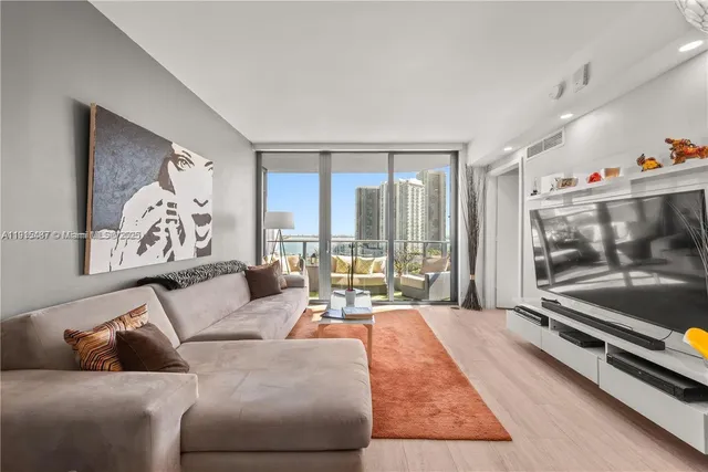 a living room with furniture and a floor to ceiling window