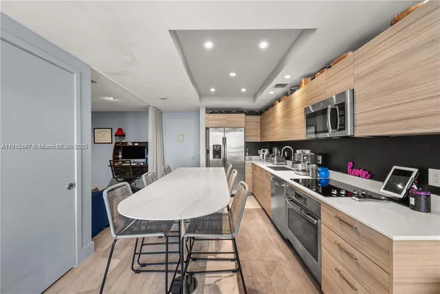 a kitchen with stainless steel appliances granite countertop a sink dishwasher a stove a microwave oven with cabinets and wooden floor