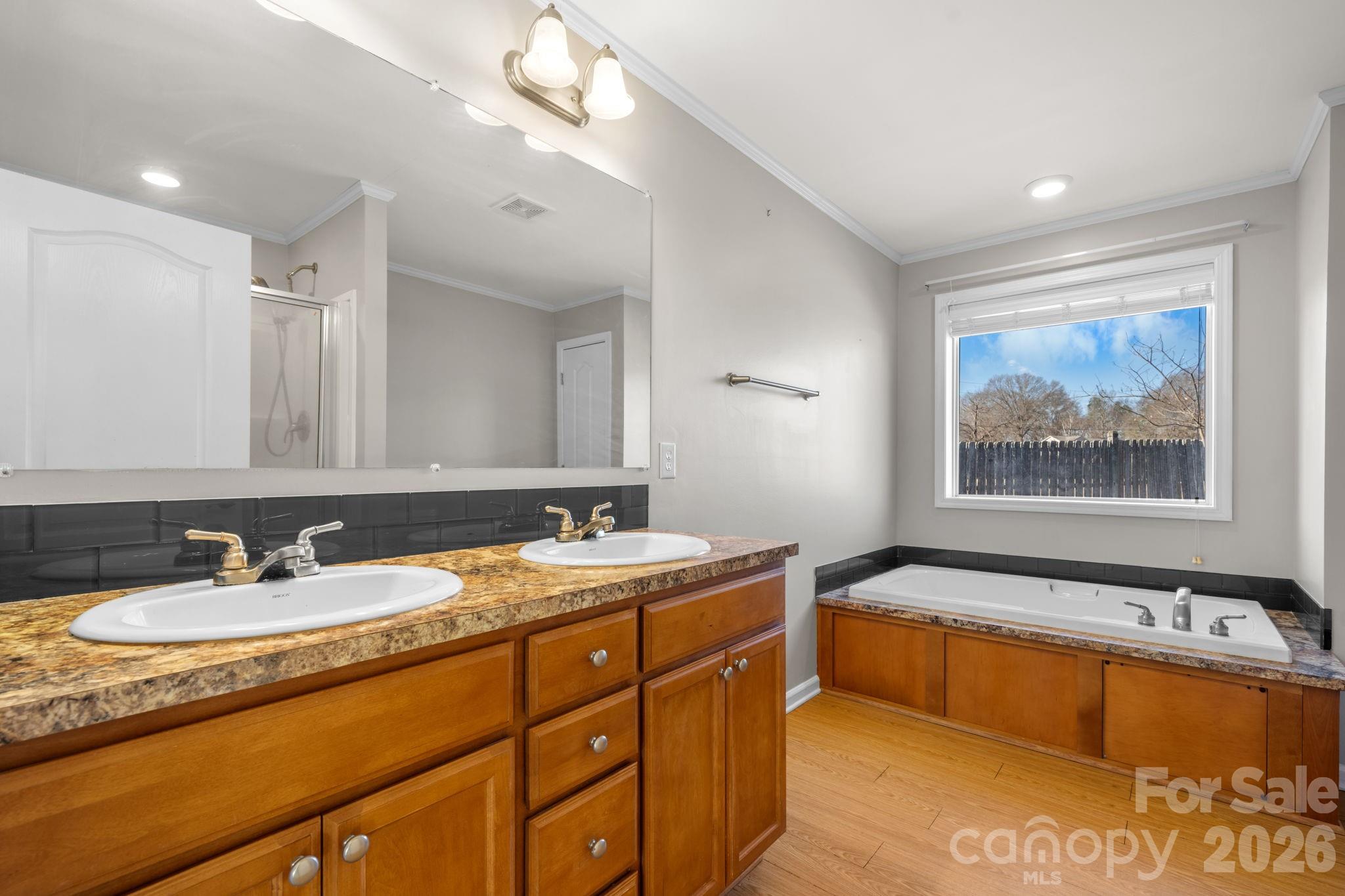 999 Stone Throw Drive Concord, NC 28025 - Photo 12 of 23 a spacious bathroom with a tub double sink and mirror