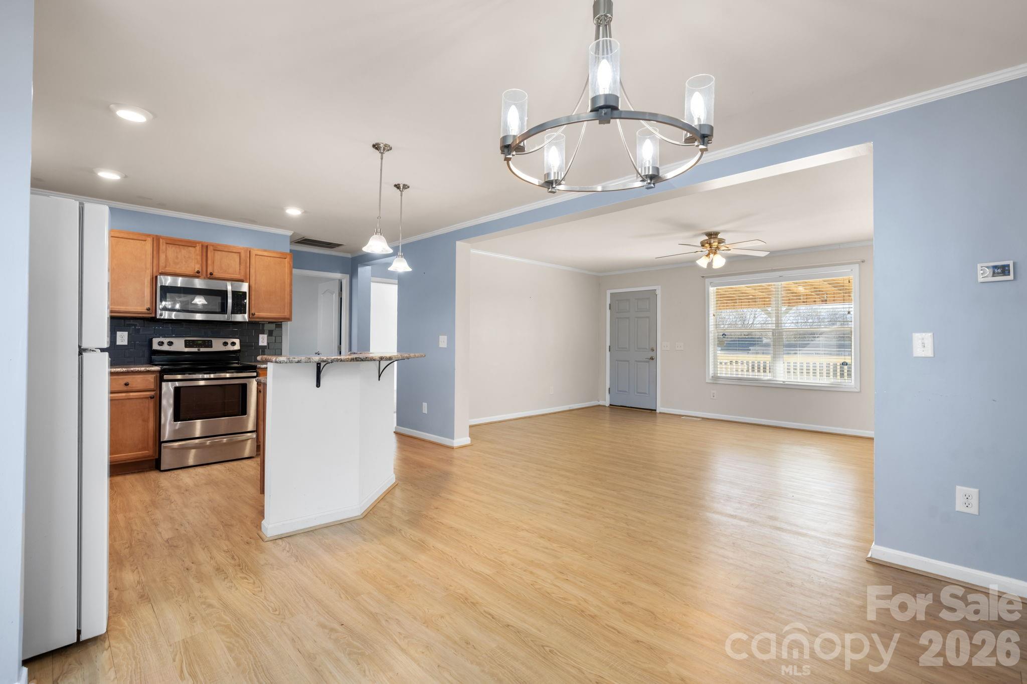 999 Stone Throw Drive Concord, NC 28025 - Photo 6 of 23 a kitchen with stainless steel appliances kitchen island granite countertop a stove top oven a sink and a refrigerator
