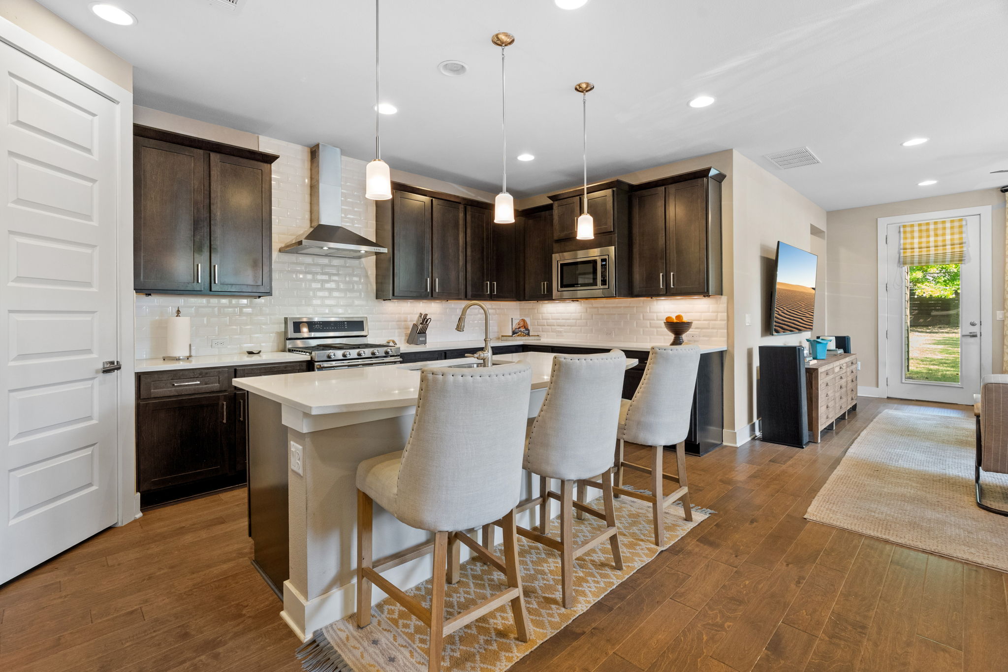 3707 Birch Street, Unit B Austin, TX 78704 - Photo 8 of 40 Modern pendant light fixtures and recessed lighting, stainless steel appliances, vent hood, and a kitchen breakfast bar. This kitchen has it all... Don't miss the pantry!