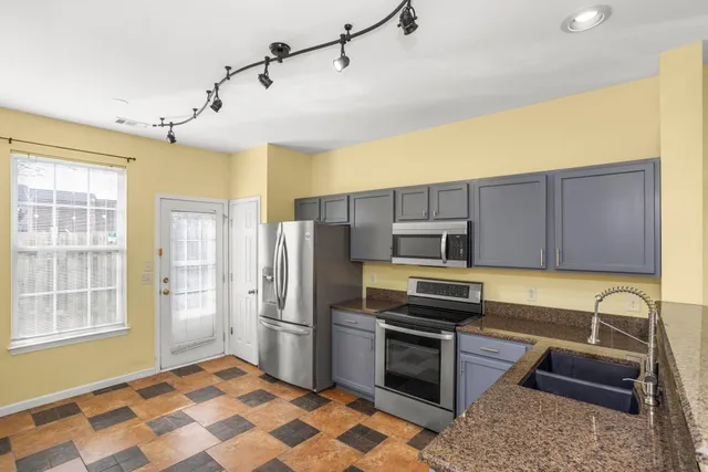 a kitchen with stainless steel appliances granite countertop a refrigerator and a stove top oven