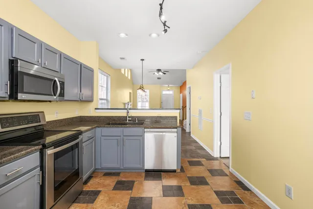 a kitchen with stainless steel appliances granite countertop a sink and a stove
