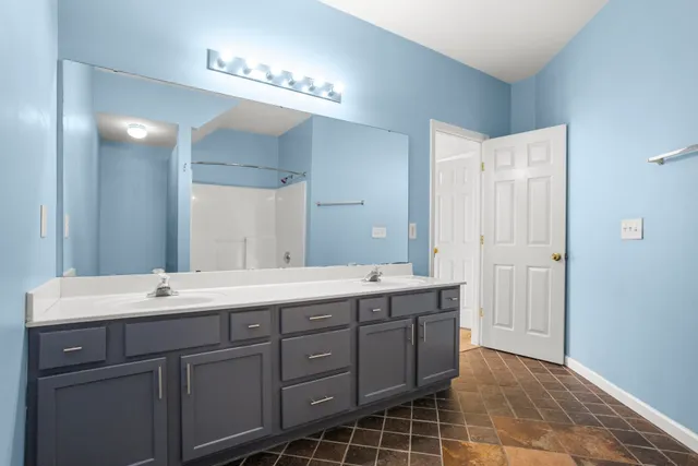 a bathroom with a double vanity sink and a mirror