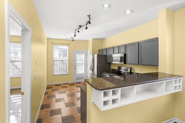 a kitchen with stainless steel appliances granite countertop a sink stove and cabinets