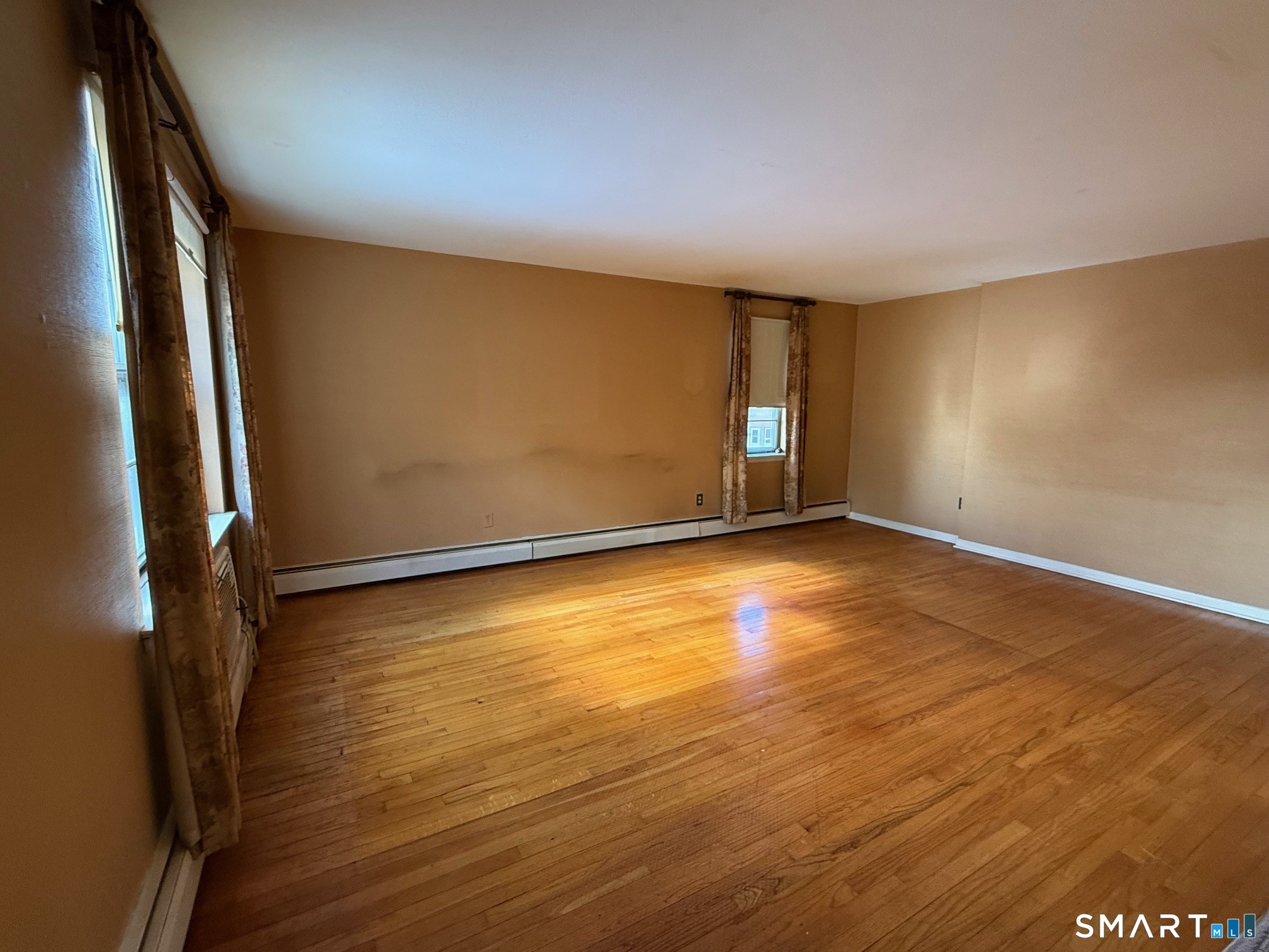 a view of room with window and wooden floor