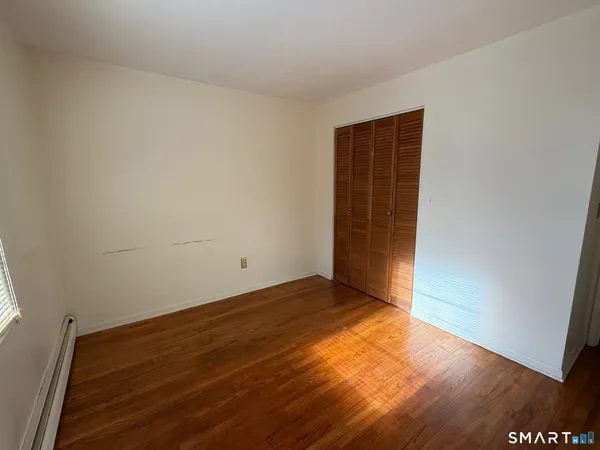 an empty room with wooden floor and closet