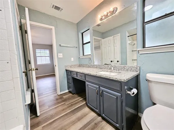 a bathroom with a granite countertop sink toilet and shower