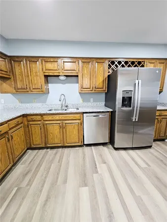 a kitchen with stainless steel appliances granite countertop a sink and a refrigerator