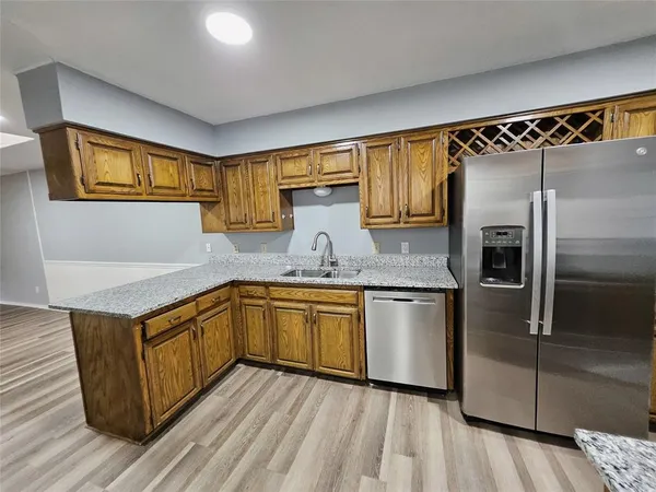a kitchen with granite countertop stainless steel appliances and wooden cabinets