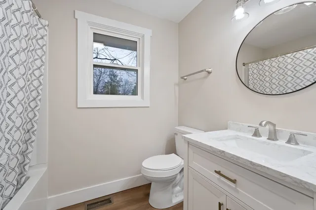 a bathroom with a toilet a sink and mirror