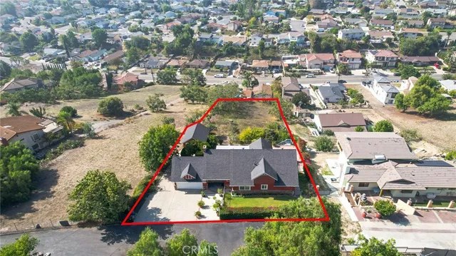 an aerial view of residential houses with outdoor space and trees