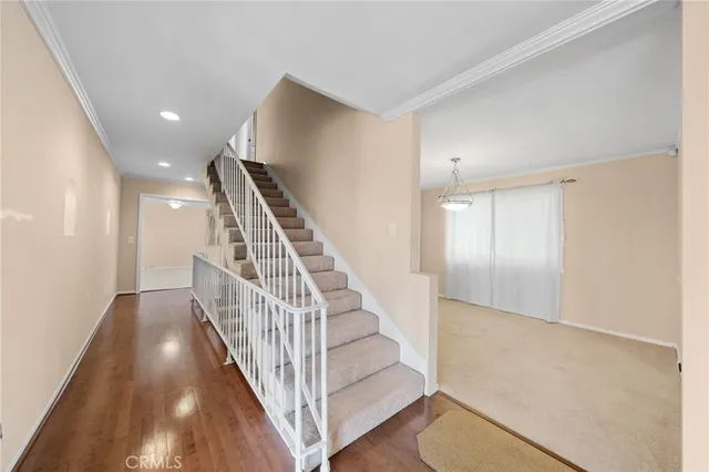 a kitchen with stainless steel appliances granite countertop a stove a sink dishwasher and a refrigerator with wooden floor