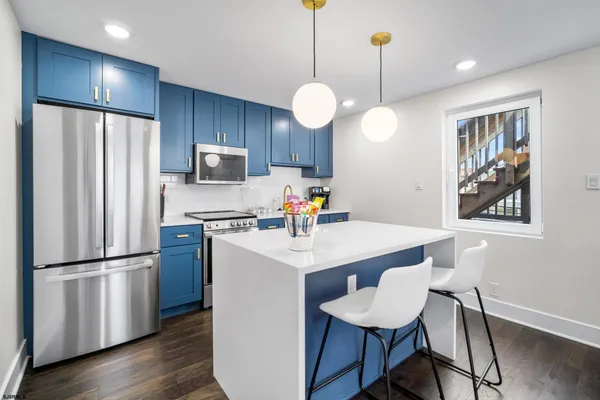 a kitchen with refrigerator cabinets and wooden floor