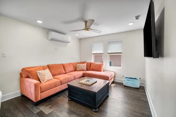 a living room with furniture a flat screen tv and a window