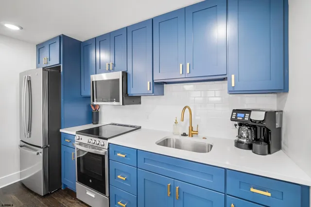 a kitchen with stainless steel appliances granite countertop a refrigerator and a sink