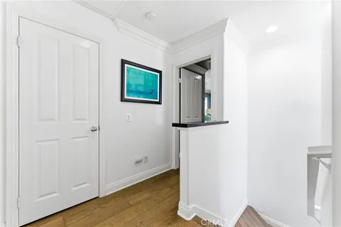 a view of a hallway with wooden floor and closet